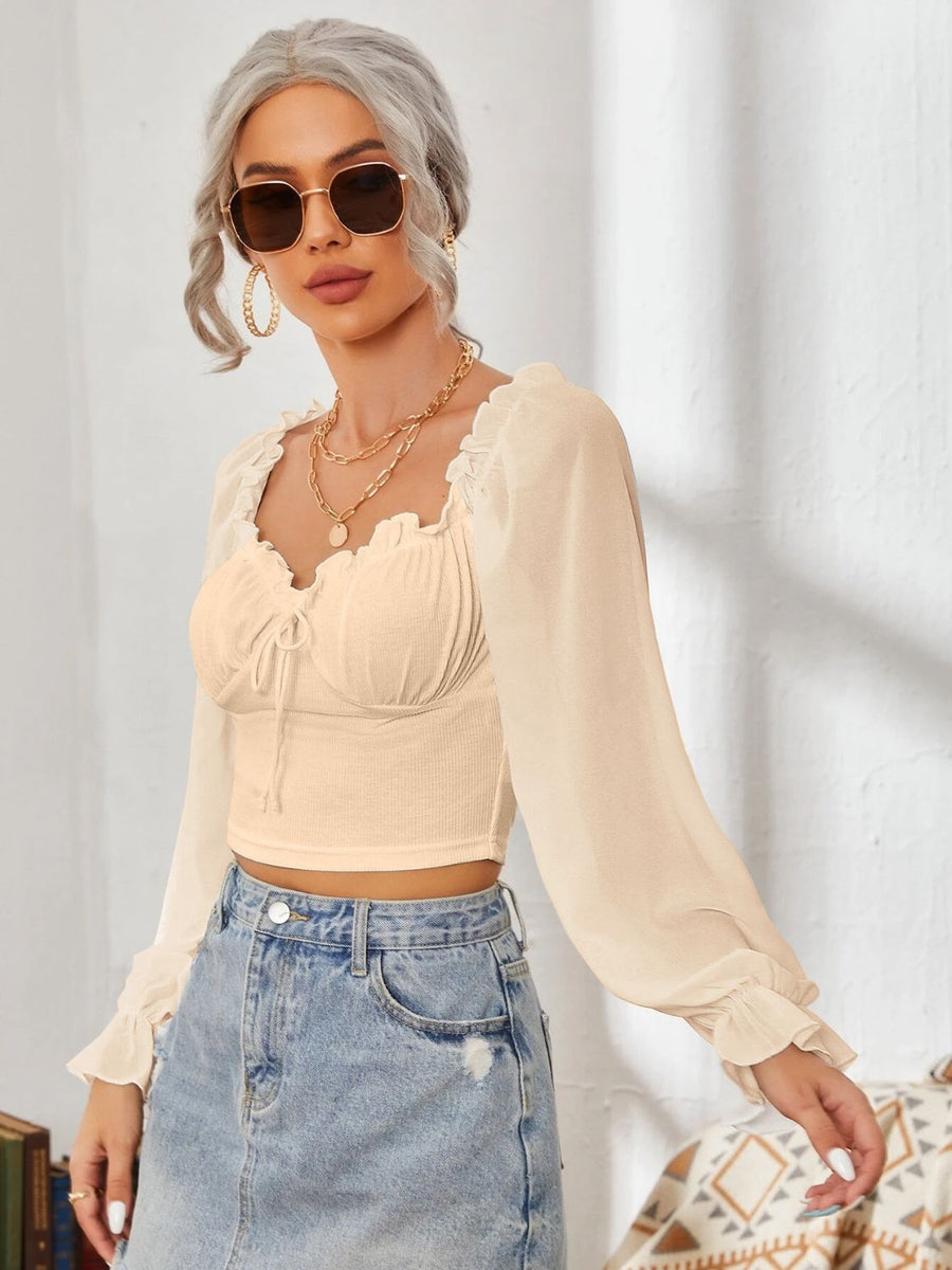 Blush pink bustier blouse with sweetheart neckline, tie front, and sheer bishop sleeves.