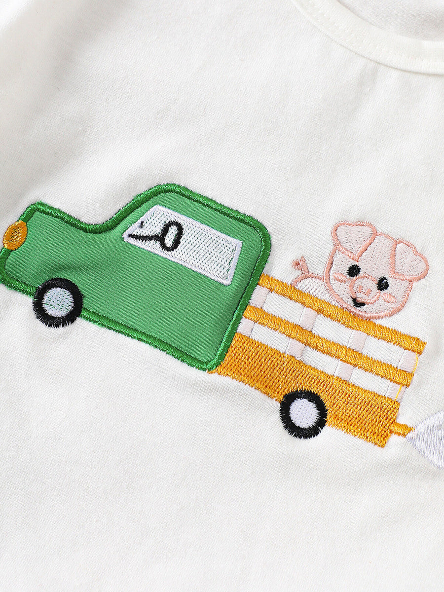 White cotton baby tee with embroidered green truck and pig detail