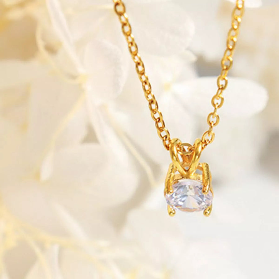 Gold zircon pendant necklace with delicate chain, showcasing a single sparkling stone.