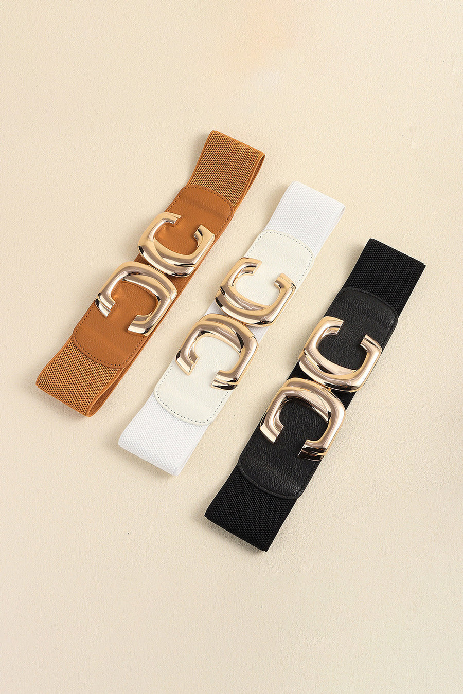 Elastic waist belt in black, caramel, and white with gold double-C buckle detail