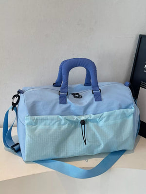 Chic two-tone nylon travel bag in aqua with detachable strap and front drawstring pocket.