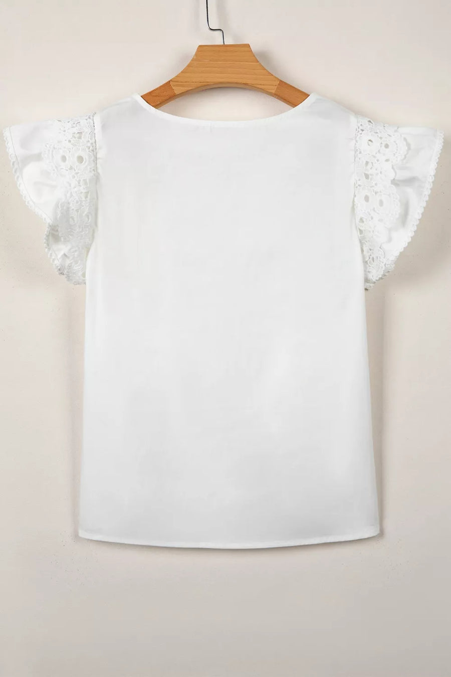 White cotton shirt with lace flutter sleeves and ruffled trim.