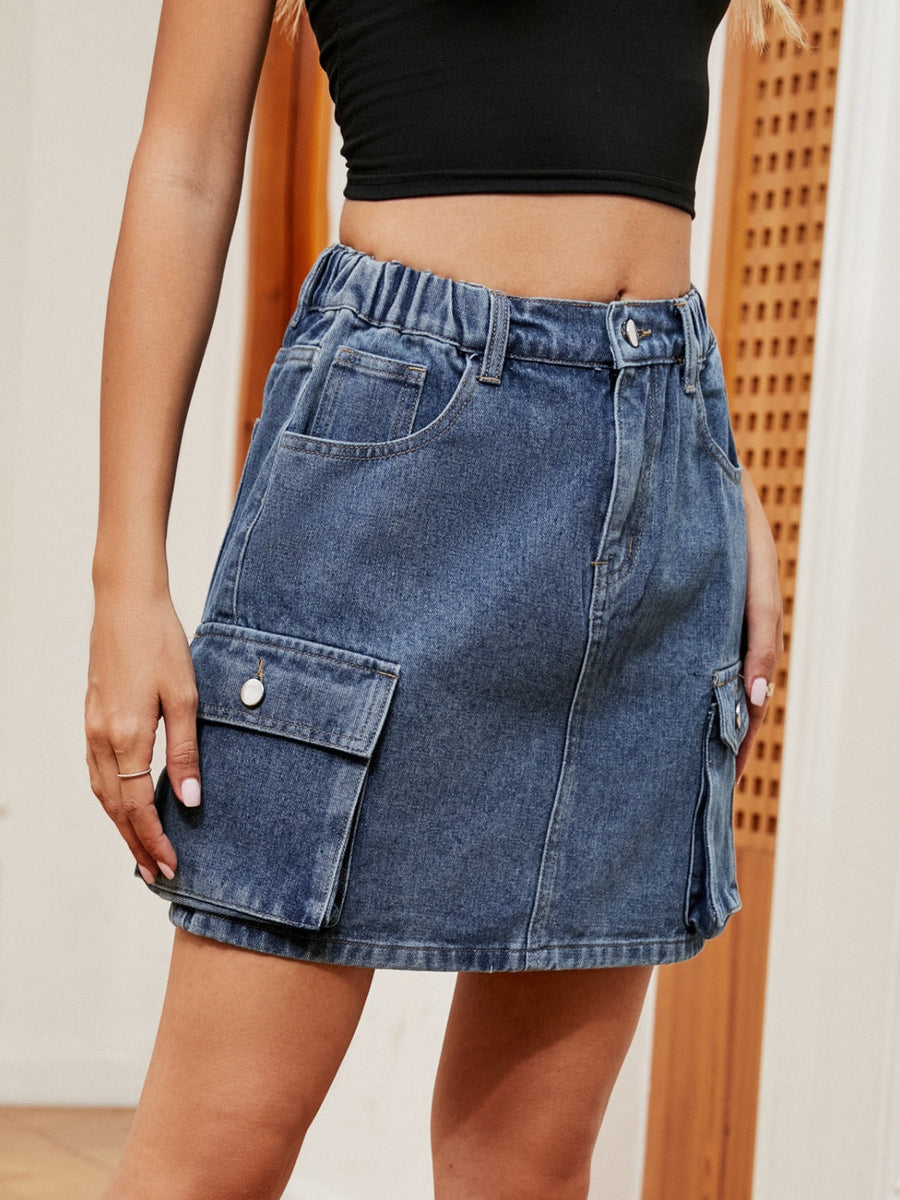Denim cargo mini skirt in dark blue with elastic waistband and button closure.
