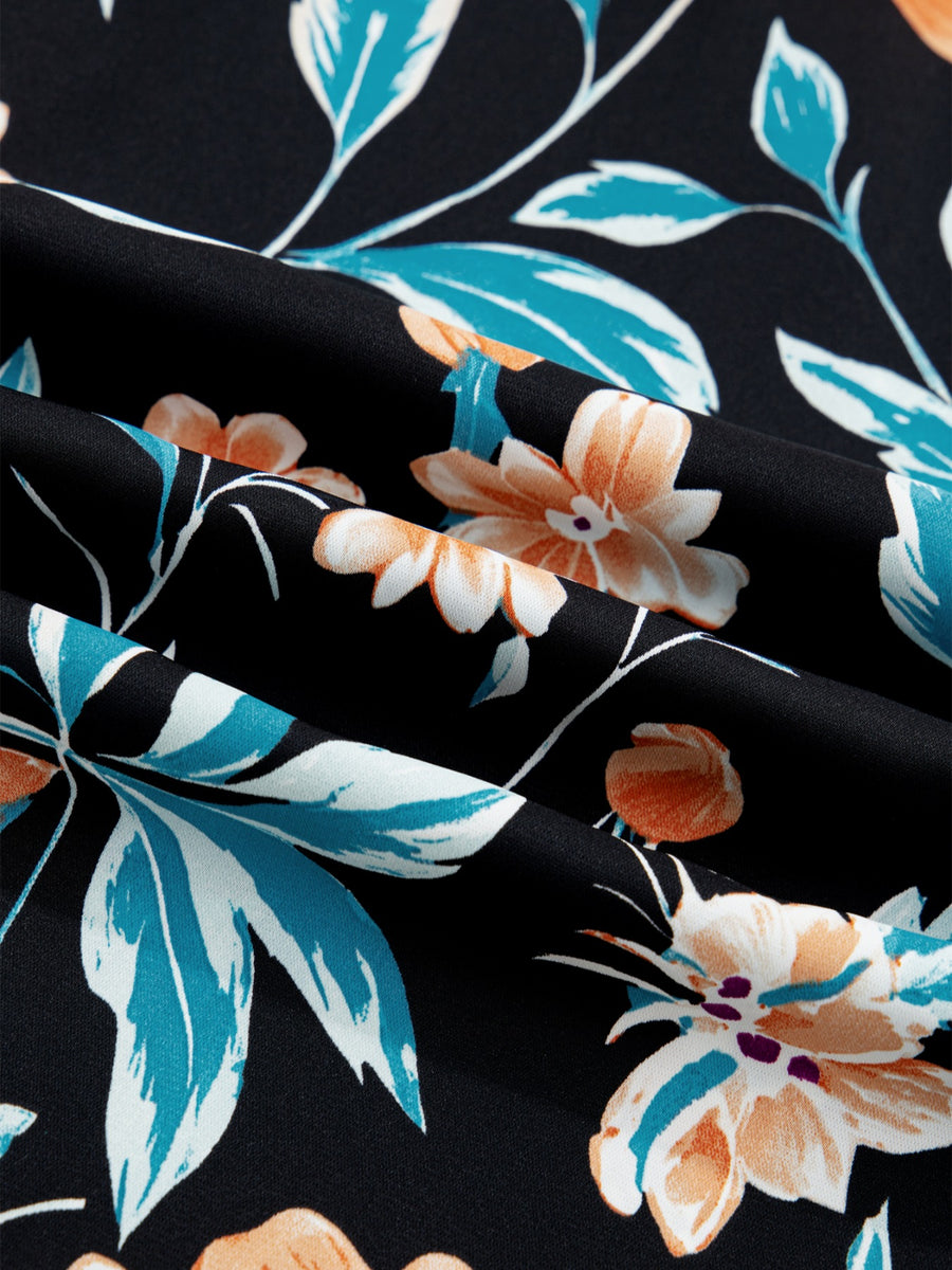 Bubble sleeve buttoned blouse in black with a floral print featuring orange and teal flowers and leaves.