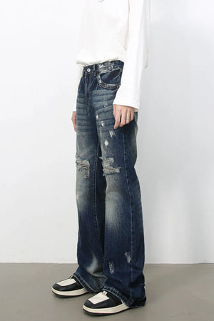 Distressed flare jeans in medium wash denim with raw edge finish and ripped details.