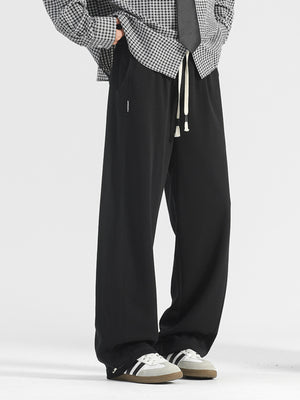 Men's black casual loose-fit drawstring pants with pockets and white drawstrings.