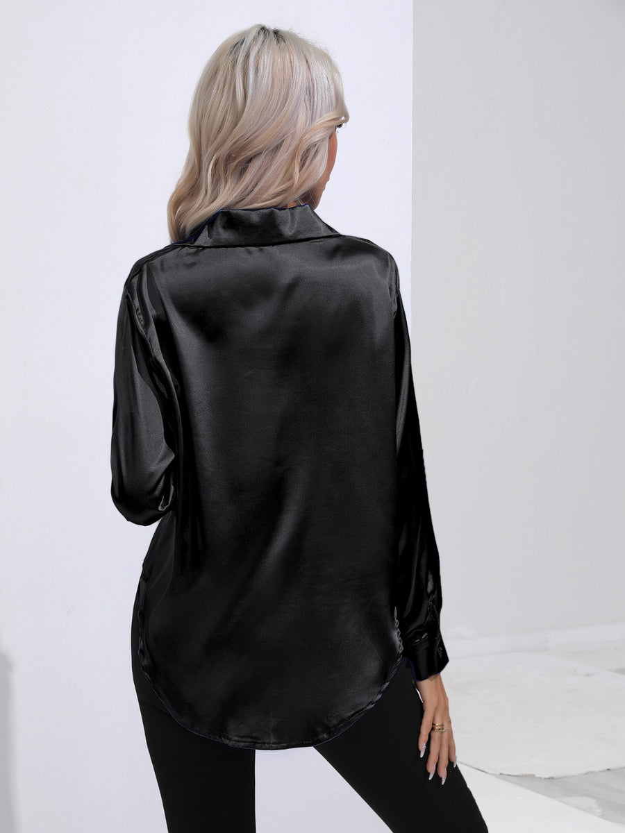 Black satin tie-front blouse with long sleeves and a curved hem.