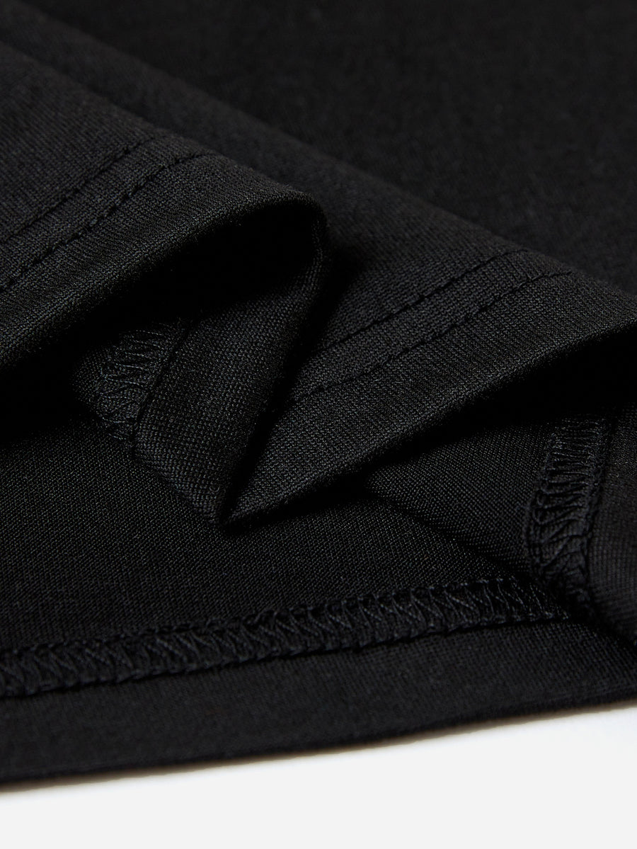 Black t-shirt detail showing textured fabric and double-stitched seams.