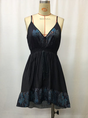 Black floral mini cami dress with V-neck, smocked waist, and ruffled hem.