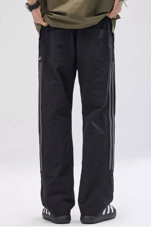 Black wide-leg cargo pants for men with reflective side stripes and back pockets.