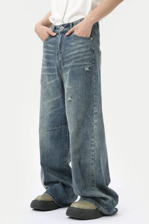 Oversized patchwork distressed denim trousers in medium wash, featuring a relaxed fit and casual styling.