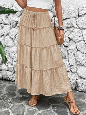 Tiered maxi skirt in tan with a drawstring waist and ruffled tiers.