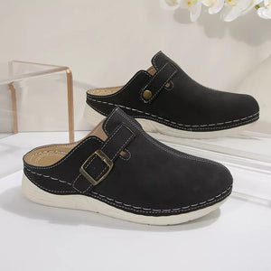 Black slip-on flats with buckle accent and contrast stitching.