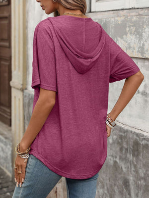 Burgundy relaxed short sleeve hooded t-shirt with a curved hem, worn by a woman.