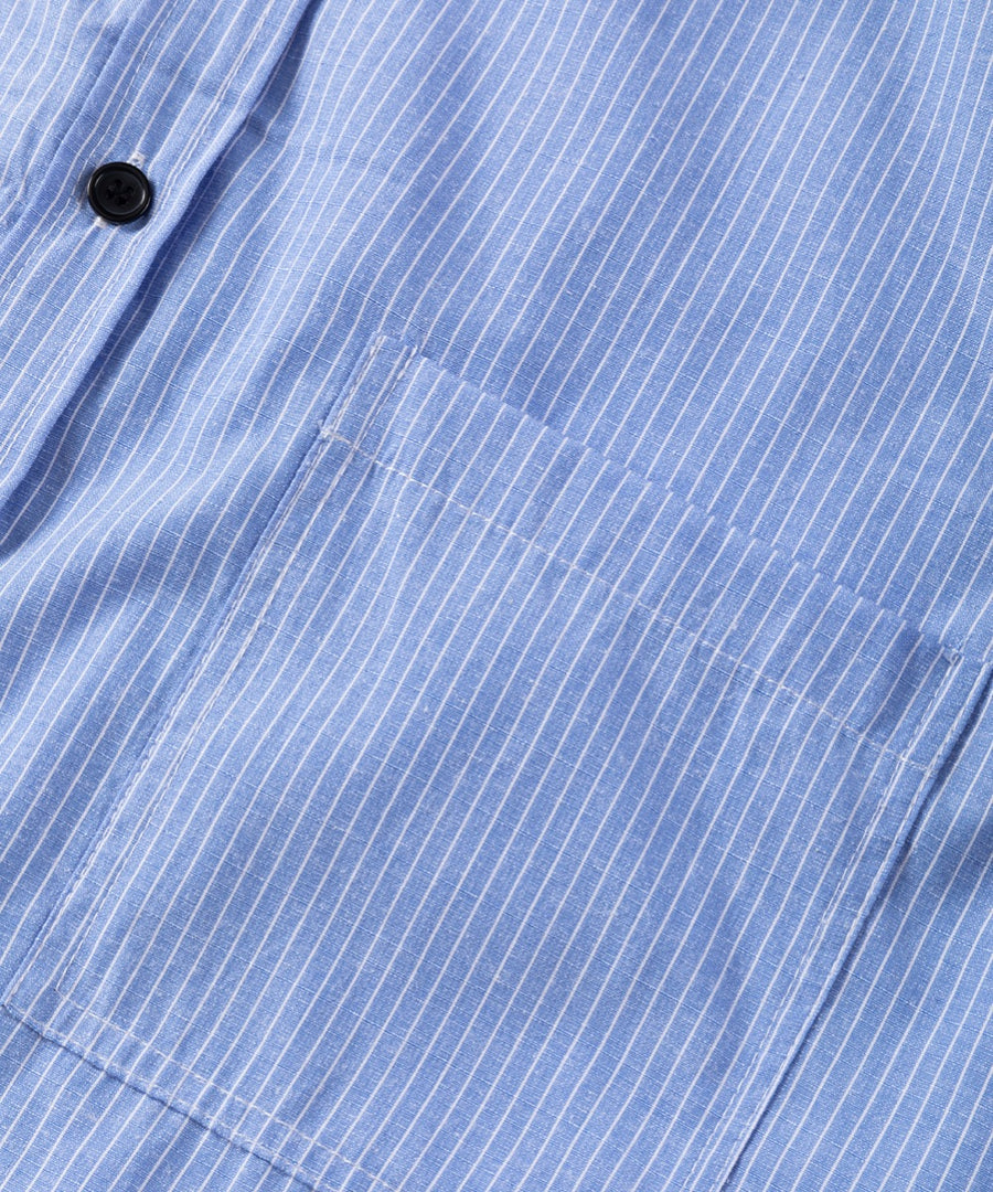 Light blue button-down shirt with white pinstripes and a chest pocket.