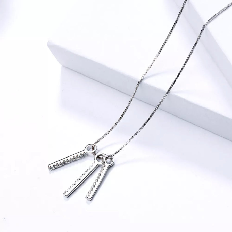 necklace in clear with geometric and tassel pendant