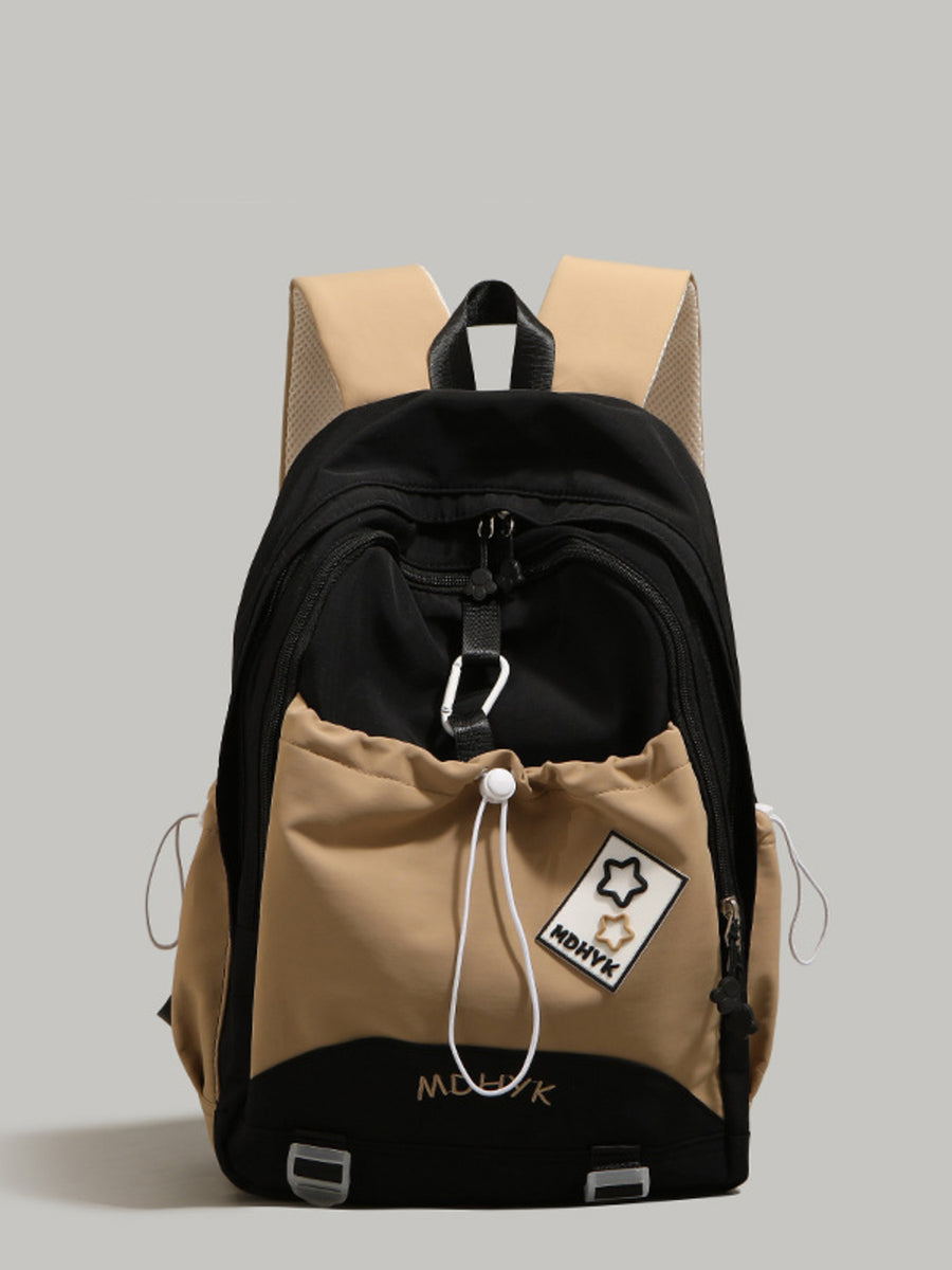 Nylon drawstring backpack in black and cream with front pocket and star patch detail.