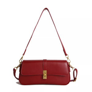 Red crossbody bag with gold clasp and adjustable strap