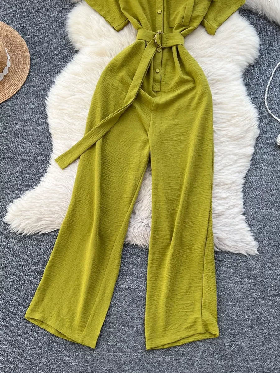 Green belted wide leg romper with button-down front and tie waist.