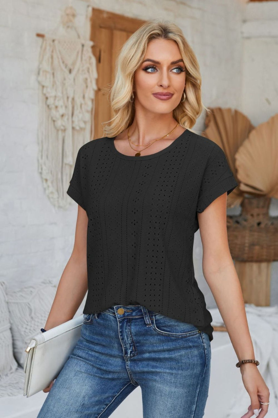 Black perforated eyelet cuffed tee with short sleeves and a round neckline.