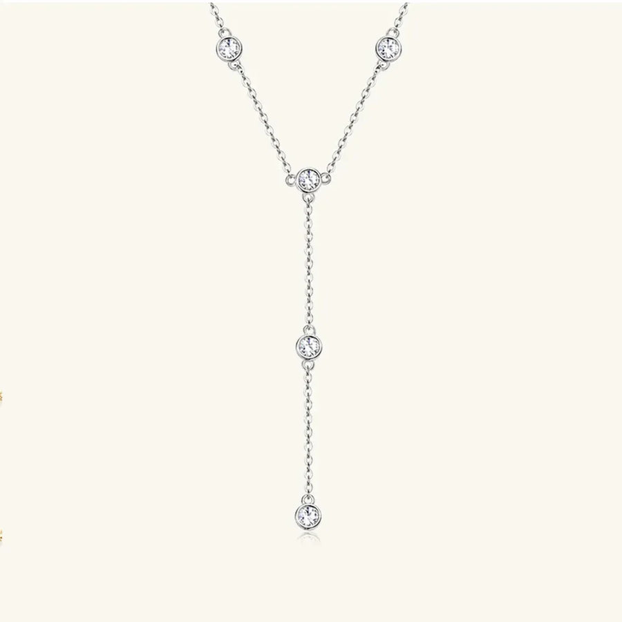 Silver lariat necklace with five bezel-set moissanite stones on a delicate chain.