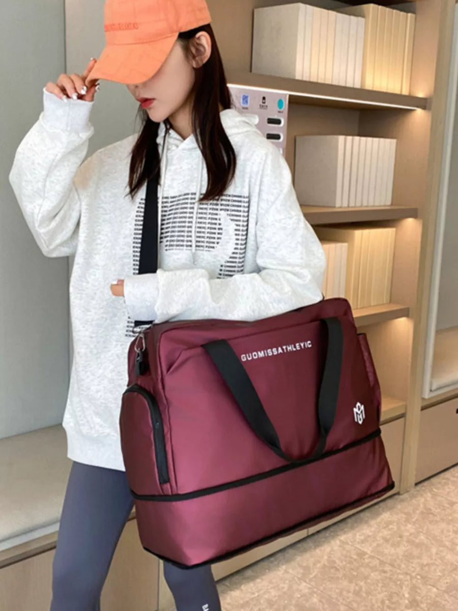 Wine red Oxford cloth travel duffle bag with adjustable strap and side pocket.
