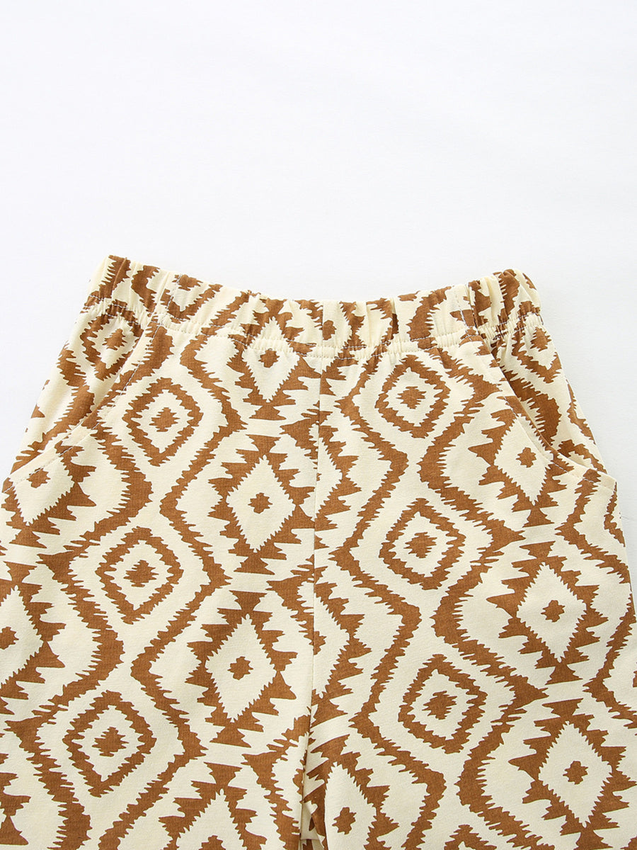 Baby shorts with elastic waist and brown diamond pattern on cream cotton.