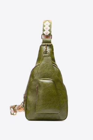 Green textured sling bag with woven strap detail and front zip pocket