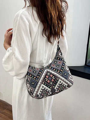Embroidered geometric hobo bag with a colorful pixelated pattern.