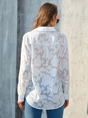 White sheer button-down blouse with floral embroidery and long sleeves.