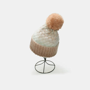 Textured ombre knit beanie with pom in camel and white, on display stand.