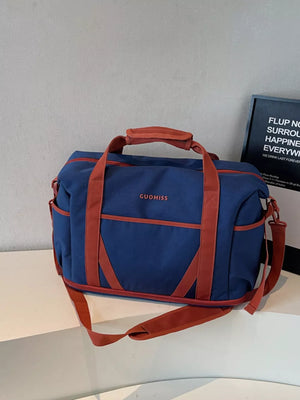 Blue duffel bag with red trim and straps, featuring "GUOMISS" logo.