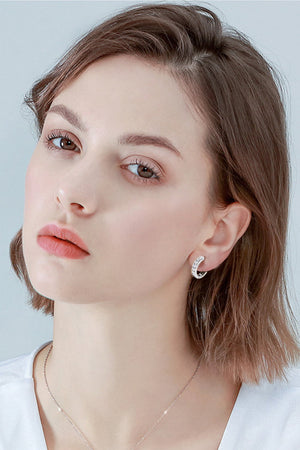 Silver moissanite channel-set hoop earrings with sparkling stones.