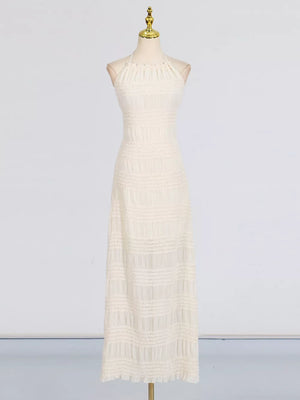 Textured halter neck maxi gown in ivory with smocked details and a ruffled hem.