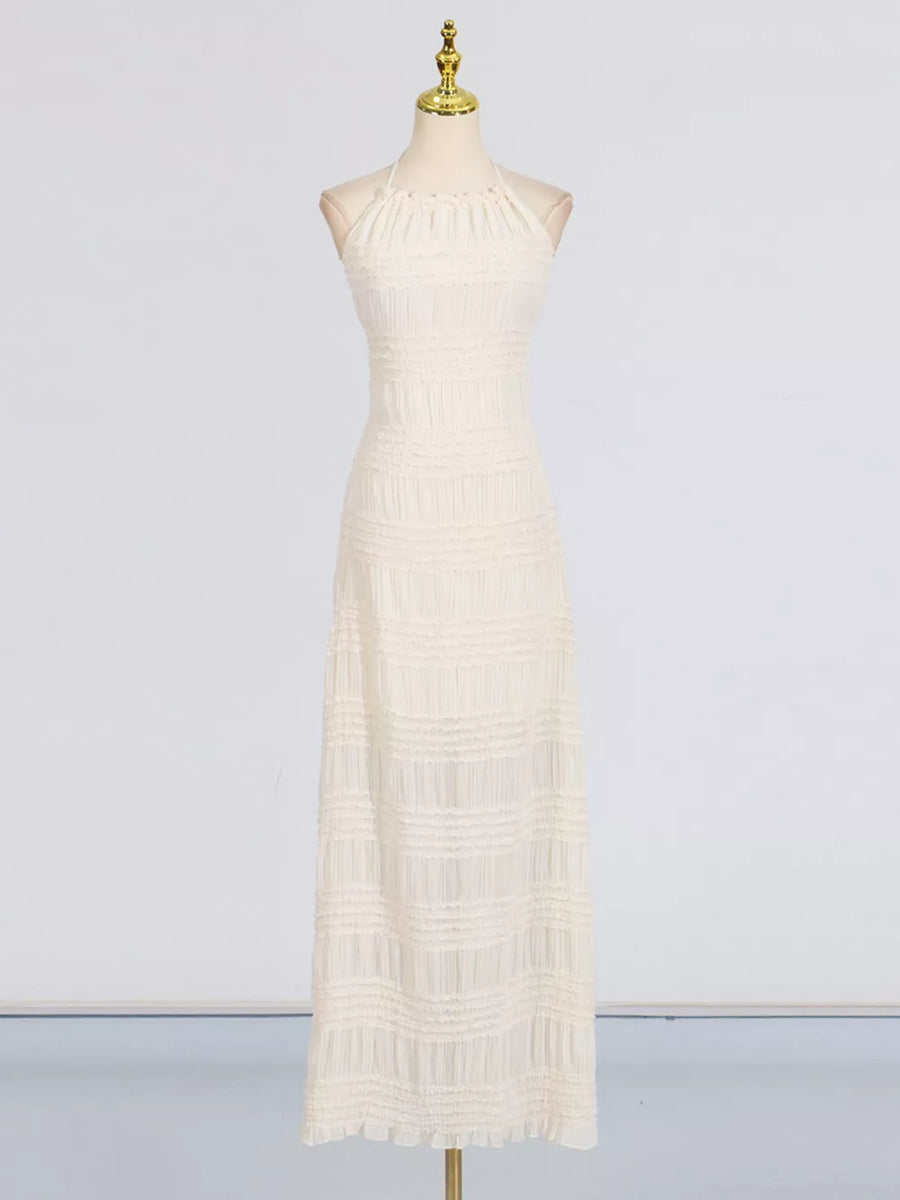 Textured halter neck maxi gown in ivory with smocked details and a ruffled hem.