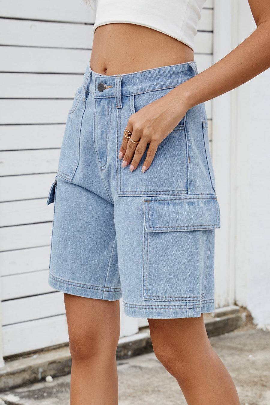 Medium wash denim cargo shorts with utility pockets and a relaxed fit.