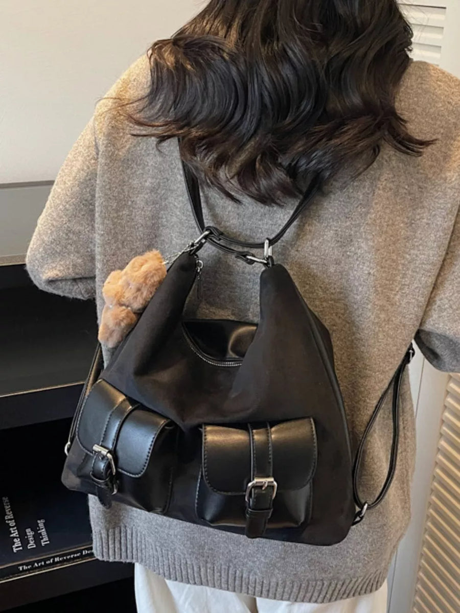 Black suede half-moon bag with double front buckle pockets and fluffy charm