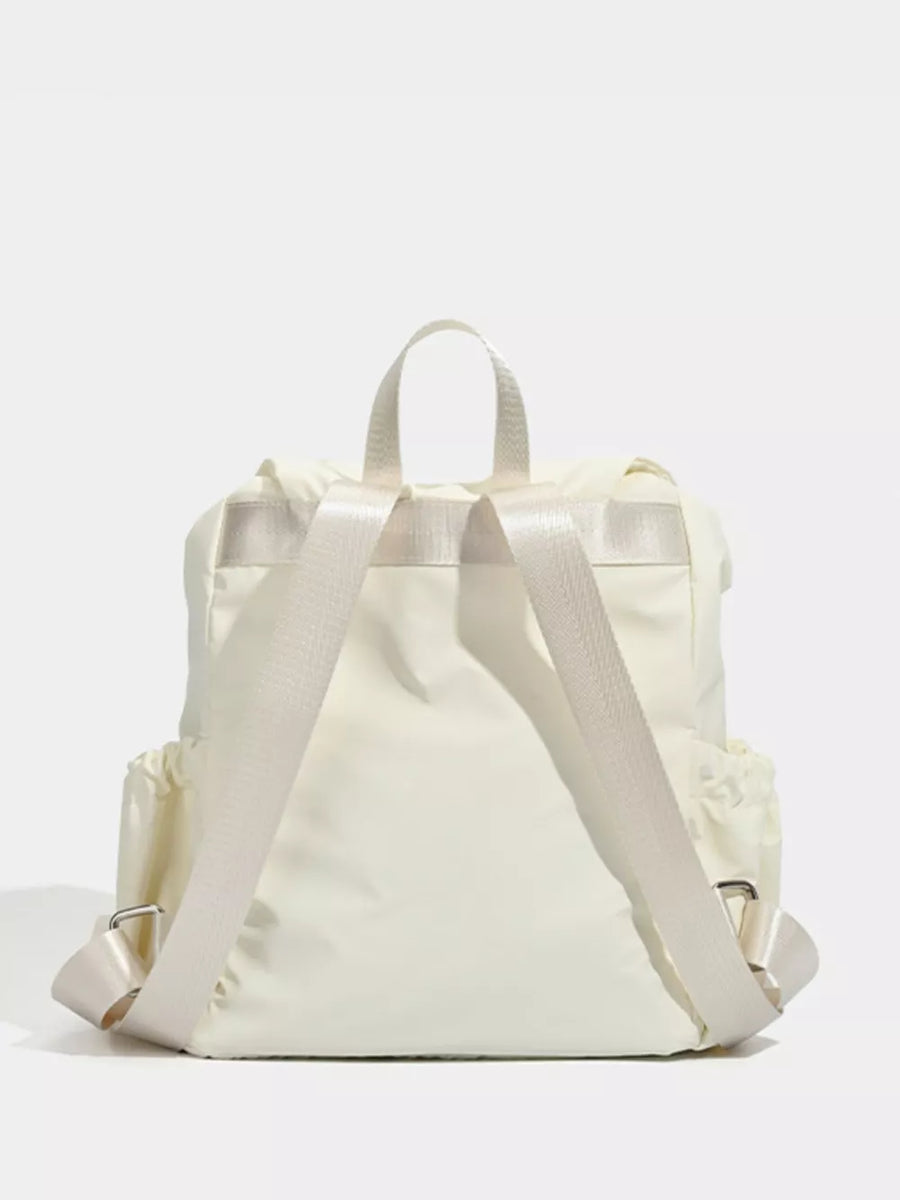Cream nylon drawstring backpack with flap closure and adjustable straps.