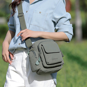 Green lightweight nylon crossbody bag with multiple pockets and zipper details.