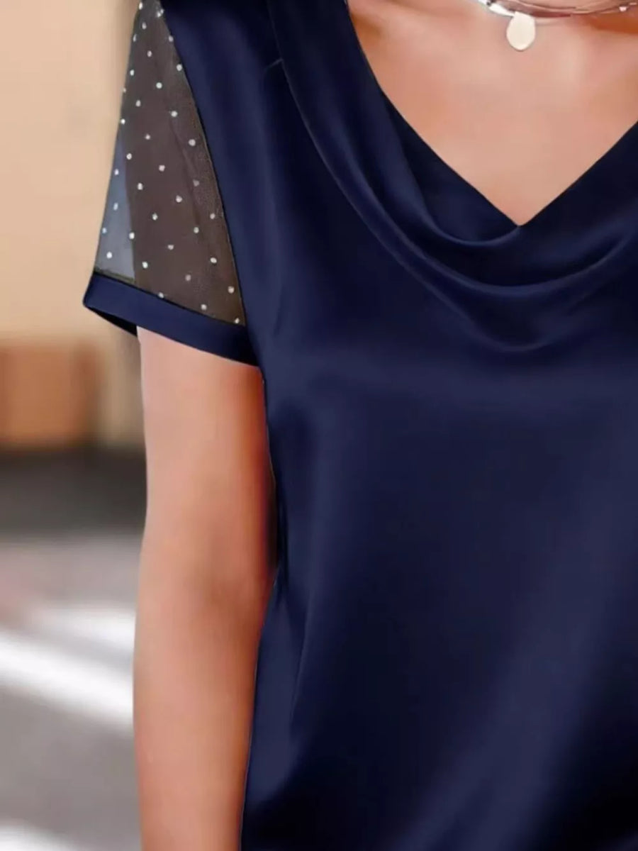 Navy cowl neck blouse with sheer polka dot sleeves and satin finish.