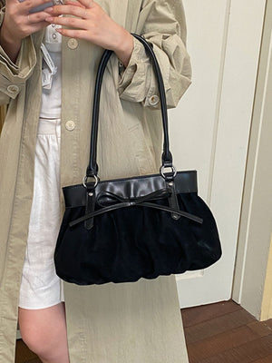 shoulder bag in black featuring bow detail and structured fit