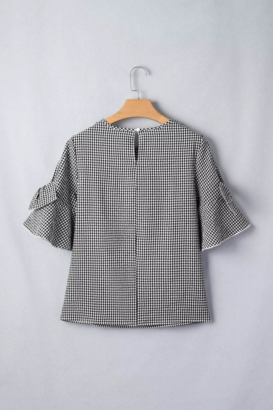 Black and white gingham polyester shirt with ruffled sleeves and a keyhole back detail.