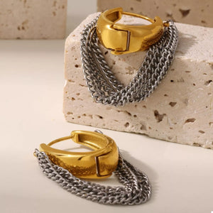 Chunky gold hoop earrings with layered silver chains.