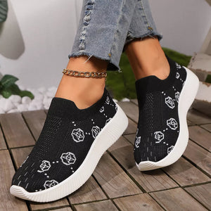 Black breathable mesh slip-on sneakers with white geometric pattern and white soles.