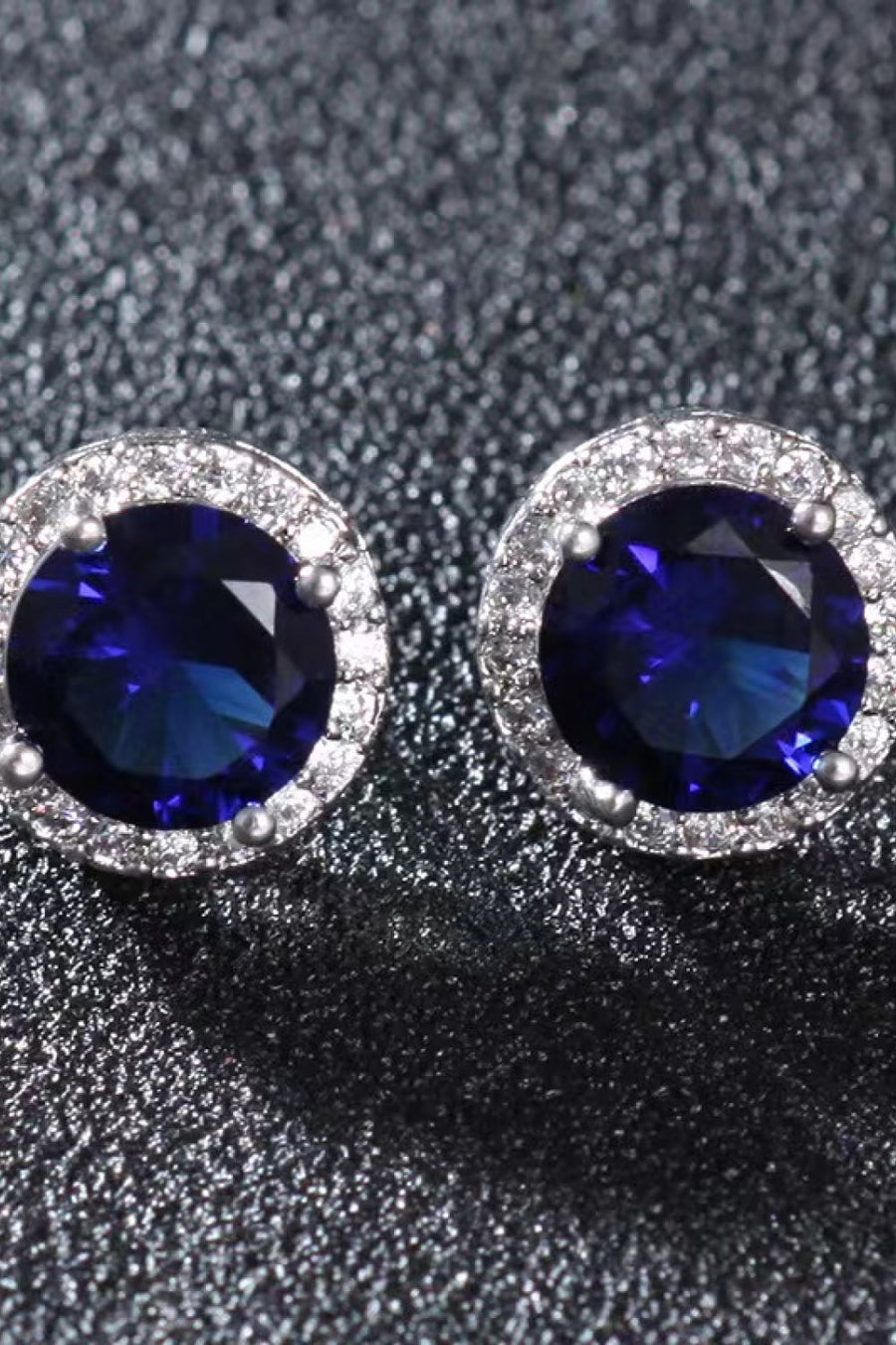 Sapphire halo stud earrings with diamond accents and silver settings.