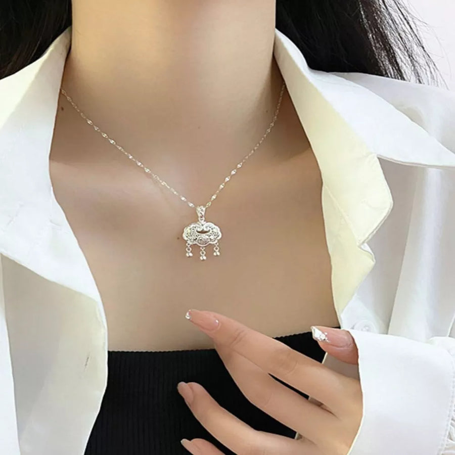 Silver necklace featuring pendant and ornate