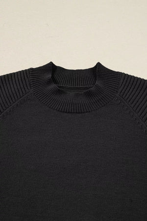 Black acrylic knit sweater with mock neck and ribbed balloon sleeves.