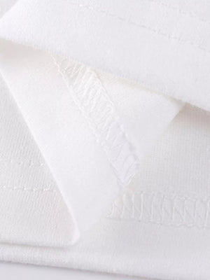 White cotton girls' undershirt detail showing stitching and fabric texture.