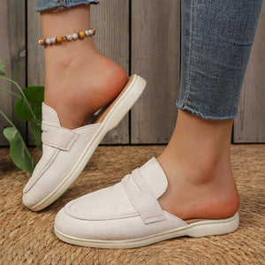 Textured white round toe slip-on loafers with backless design and strap detail.
