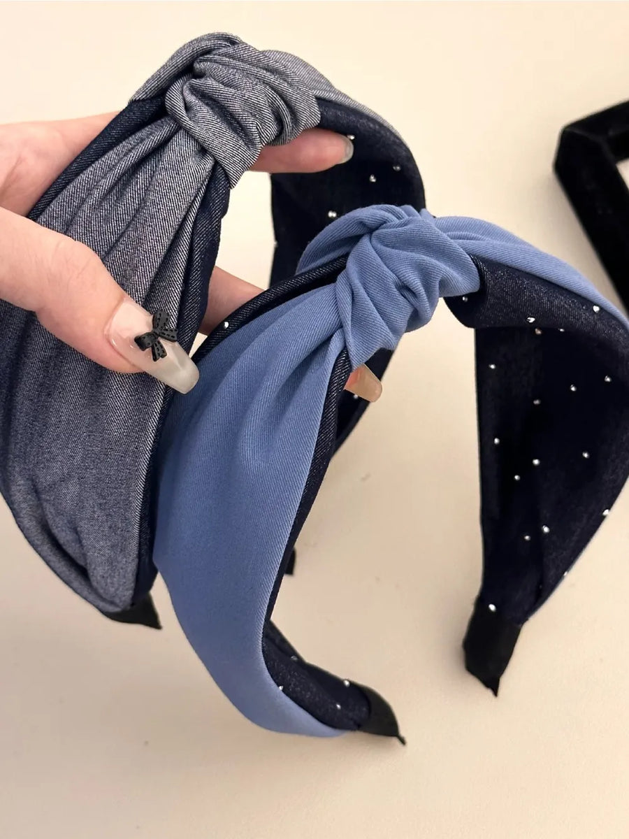 Denim knot headband in dark gray with crystal detail and blue accent.